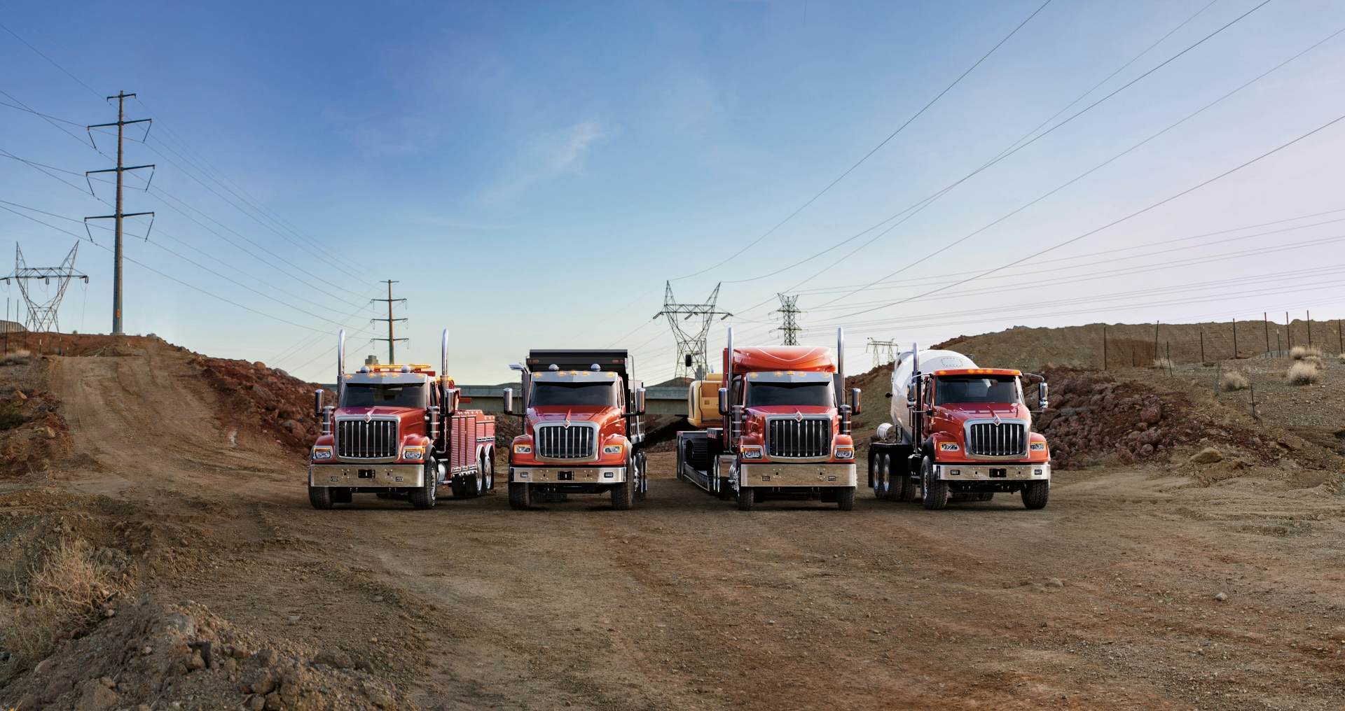 A group of trucks parked on a dirt road