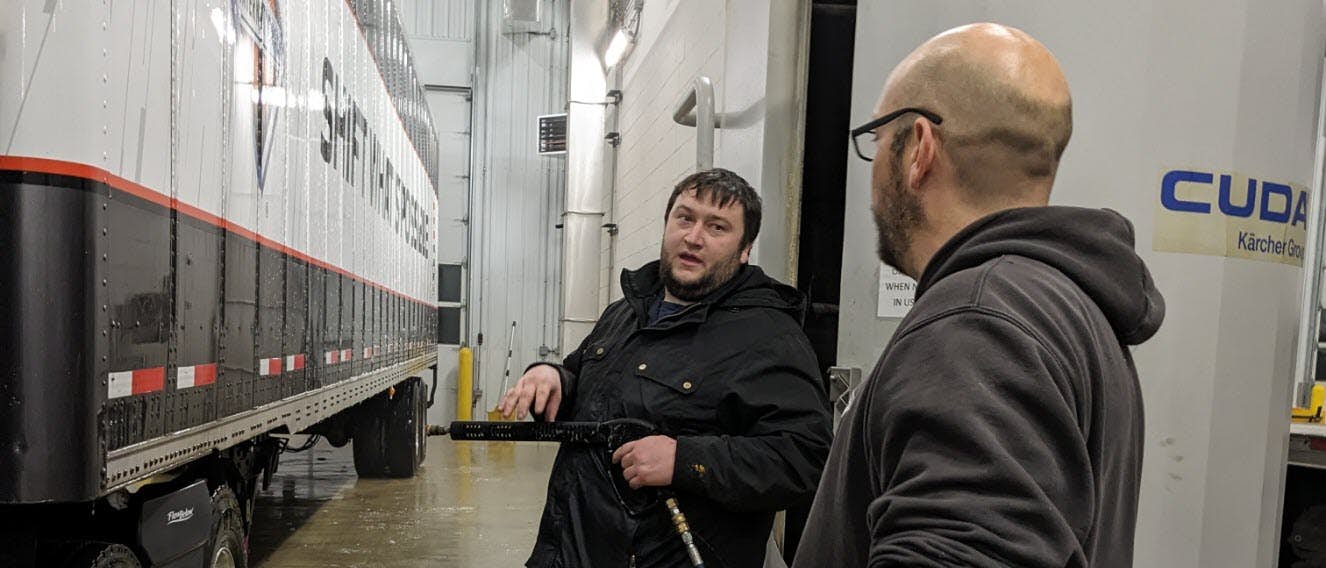 Two employees talking about truck