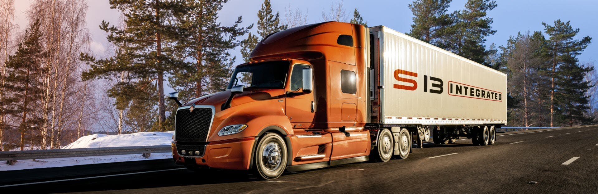 International Truck driving on highway through woods