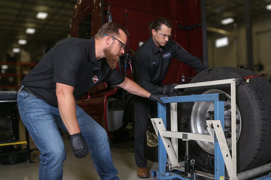 A couple of men working on a tire